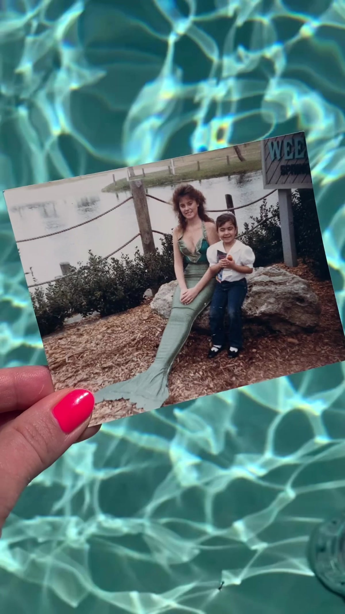A childhood photograph with a mermaid performer held over turquoise water | Lily Frank Jewelry