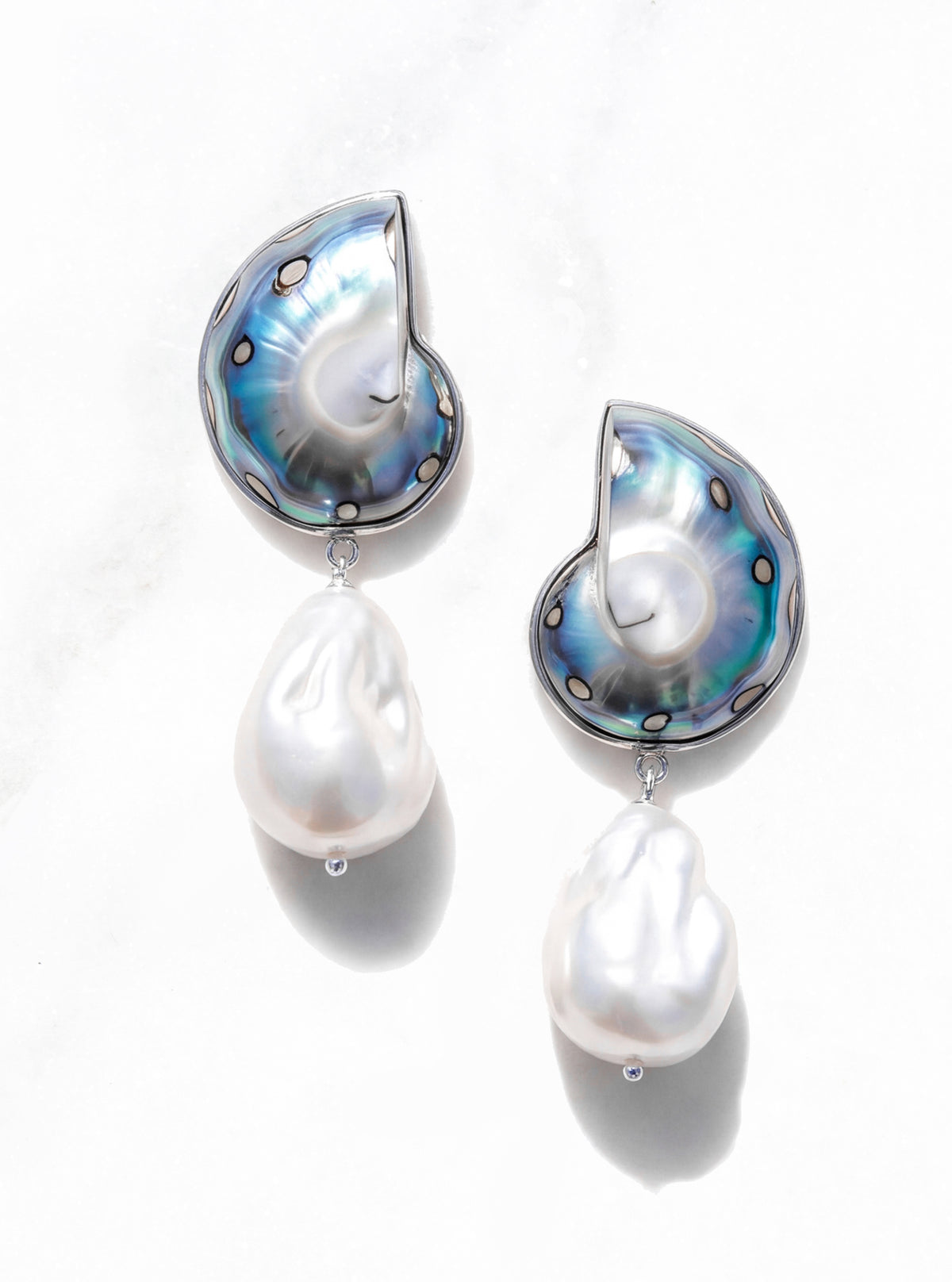 a product photo of the 926 silver encased jaguar nautilus shell drop earrings with large baroque pearl on a white marble background | Lily Frank Jewelry 
