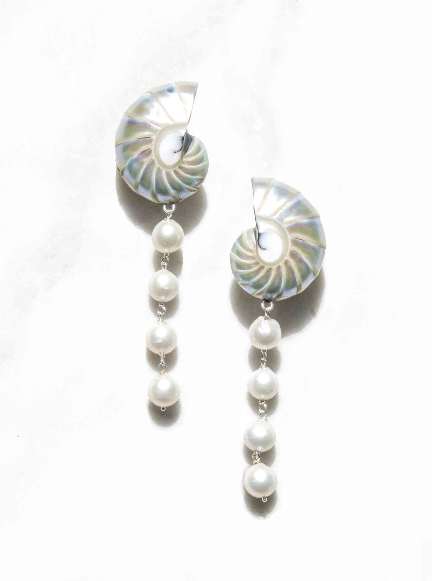 a pair of large pearl nautilus shell cascade earrings with baroque pearls in 925 silver, flat lay over a white background — Lily Frank Jewelry