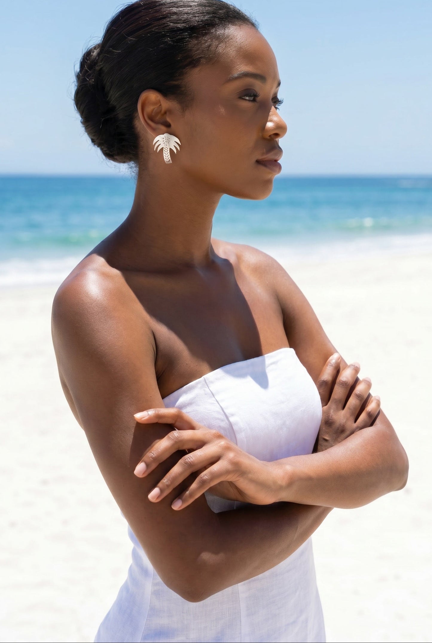 Vintage 925 silver palm tree earrings on model at beach — Lily Frank Jewelry
