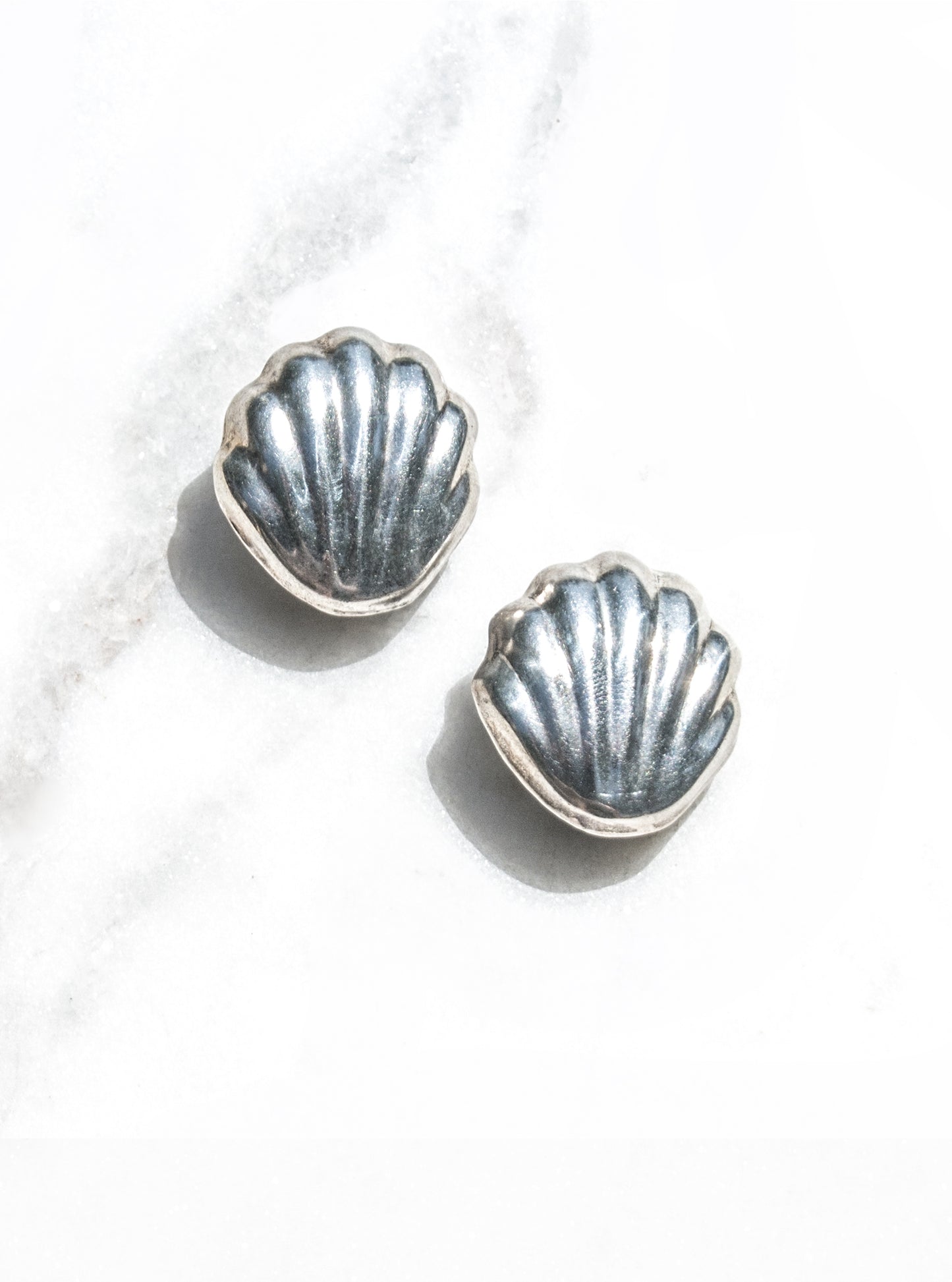 Vintage 925 silver shell earrings with sculptural radiating ridges displayed flat-lay — Lily Frank Jewelry