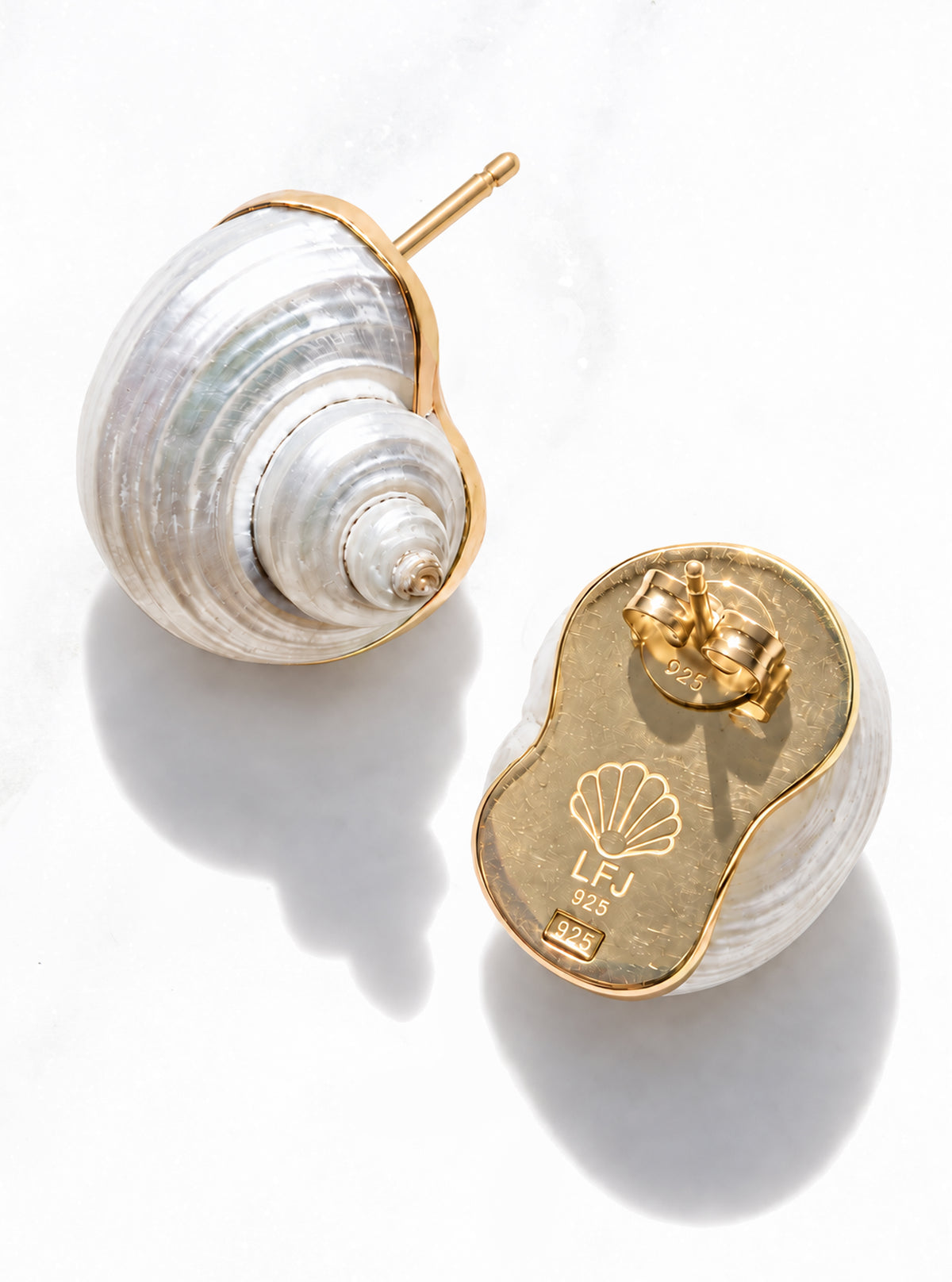 The Betsy turban shell earrings against a white marble background showcasing the solid 18k gold backplate | Lily Frank Jewelry 