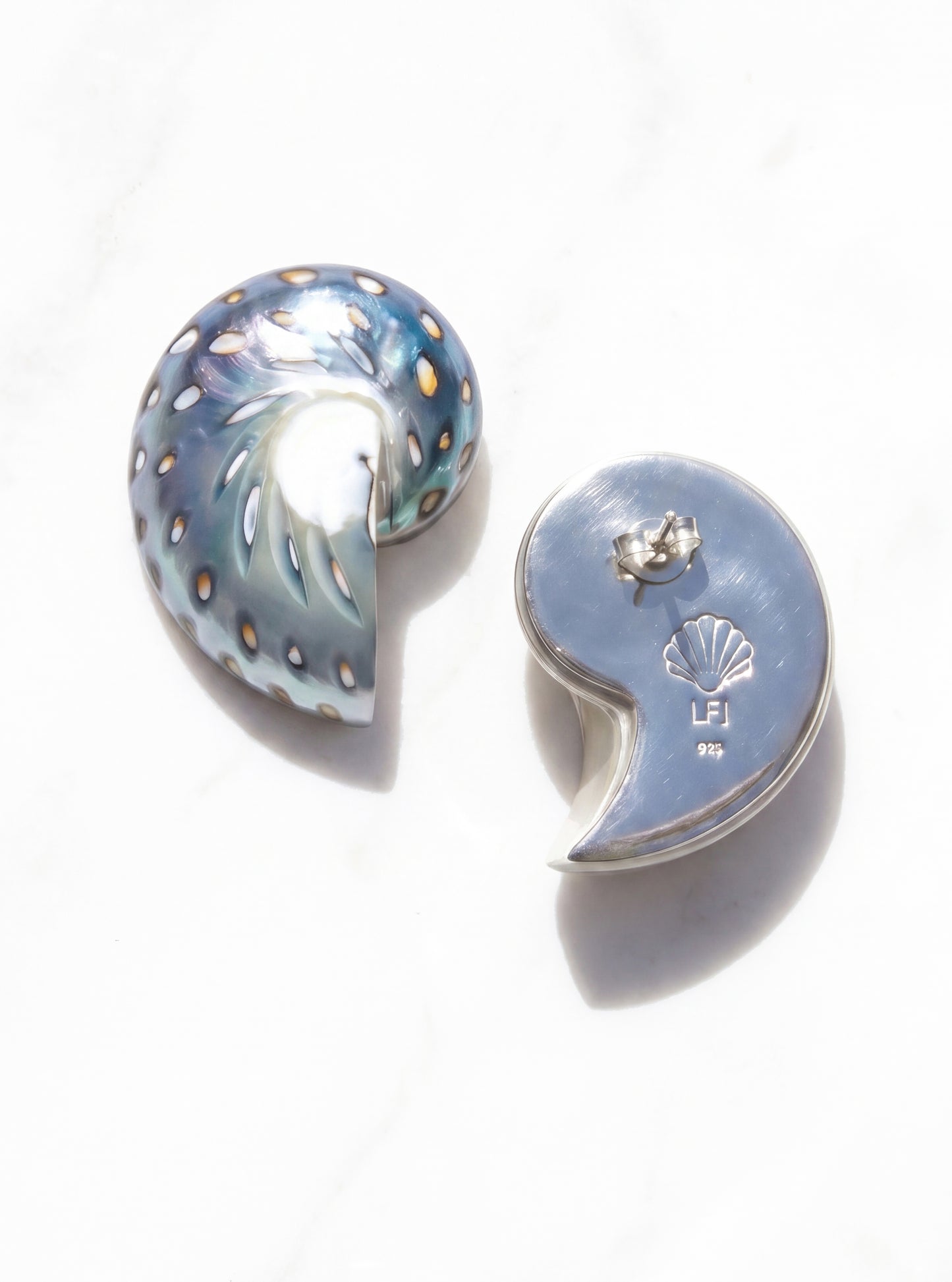 Pair of medium jaguar shell earrings on white sand | Lily Frank Jewelry