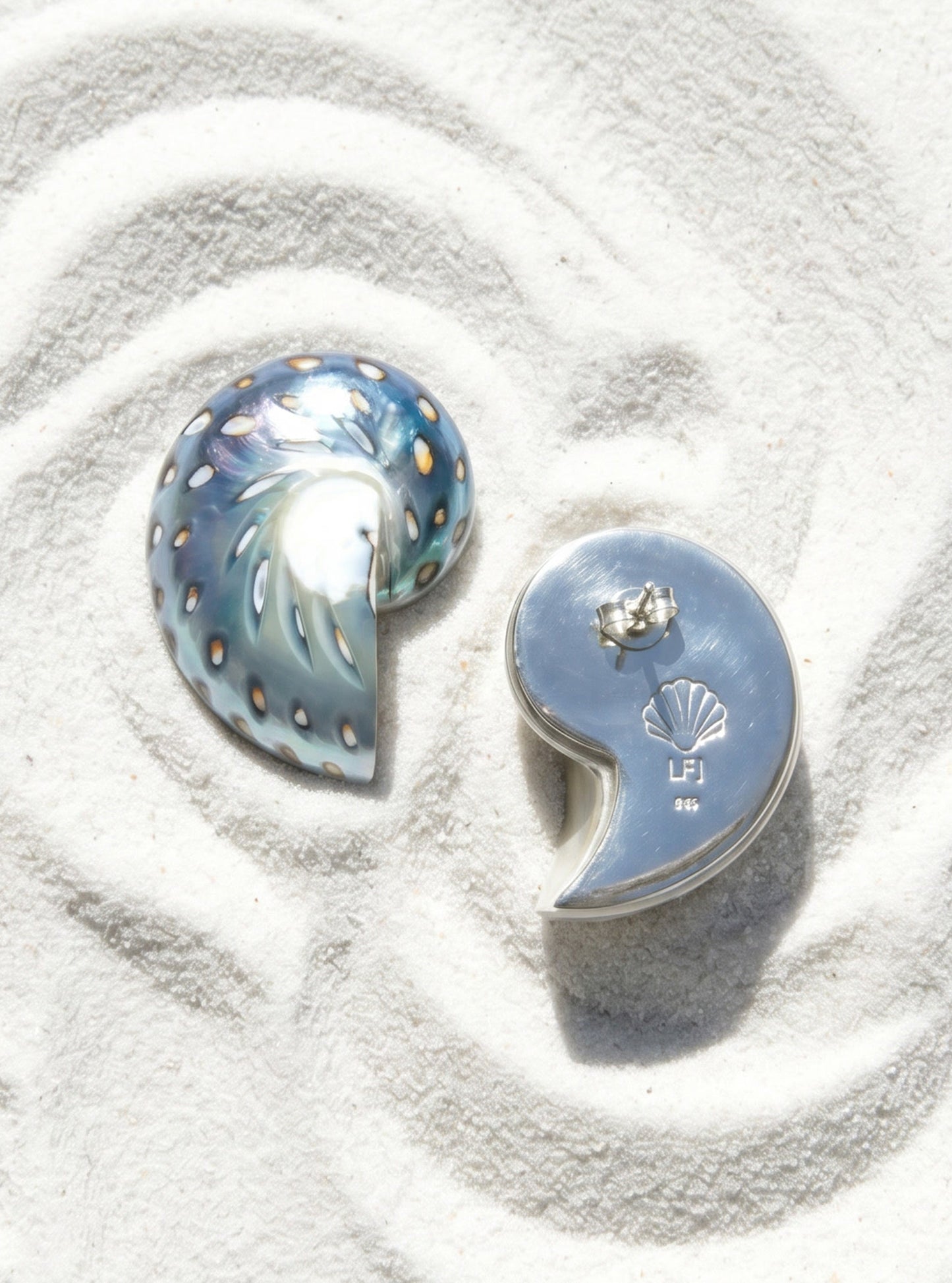 Pair of medium jaguar shell earrings with shell design on white sand | Lily Frank Jewelry