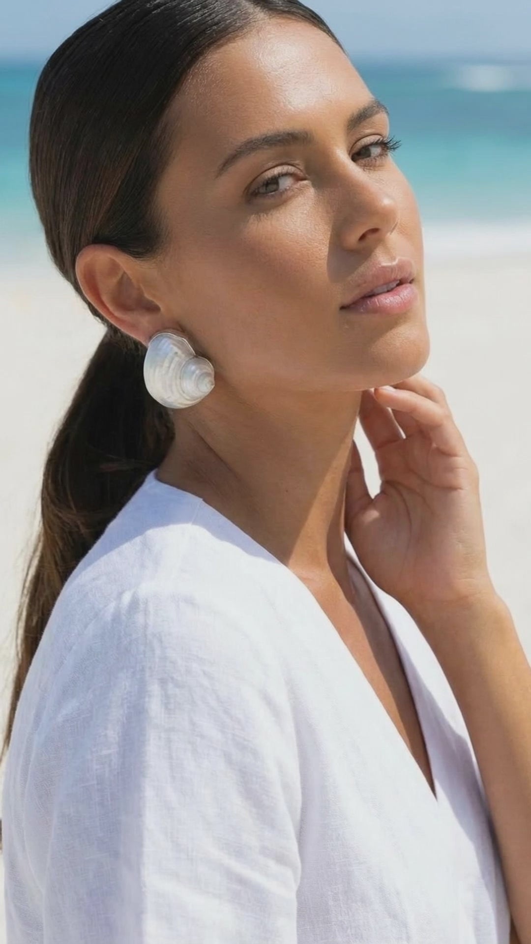A video featuring a beautiful model wearing a pair of betsy turban shell earrings on a beach | Lily Frank Jewelry 