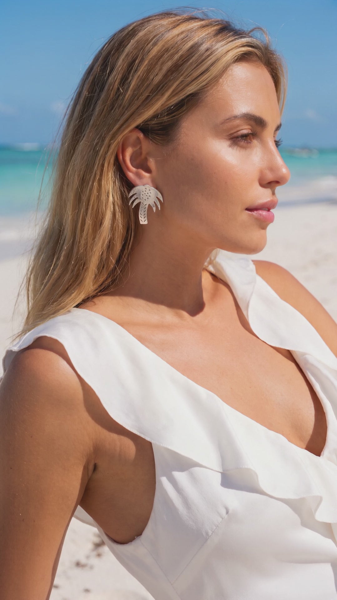 a woman in a ruffled white silk dress wears the vintage 925 silver palm tree earrings on a beach | Lily Frank Jewelry