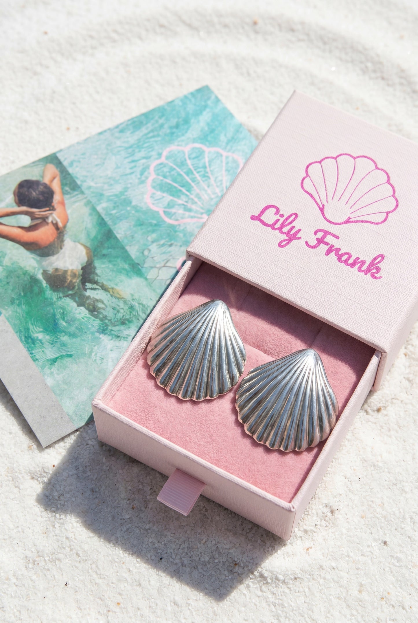 a pair vintage oversized 925 silver shell earrings in a pink box with 'Lily Frank' branding on a sandy background | Lily Frank Jewelry 